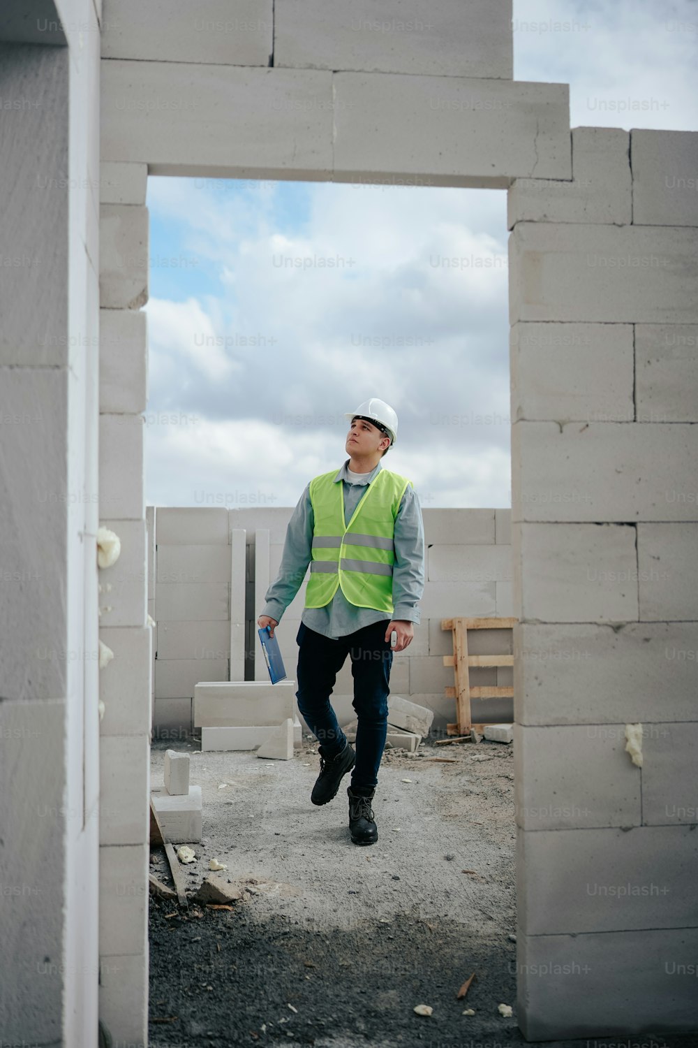 um trabalhador da construção civil andando por um canteiro de obras
