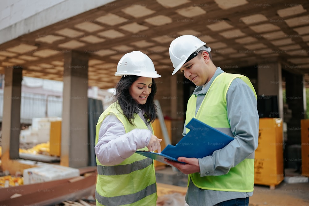 a man and a woman wearing hard hats and safety vests