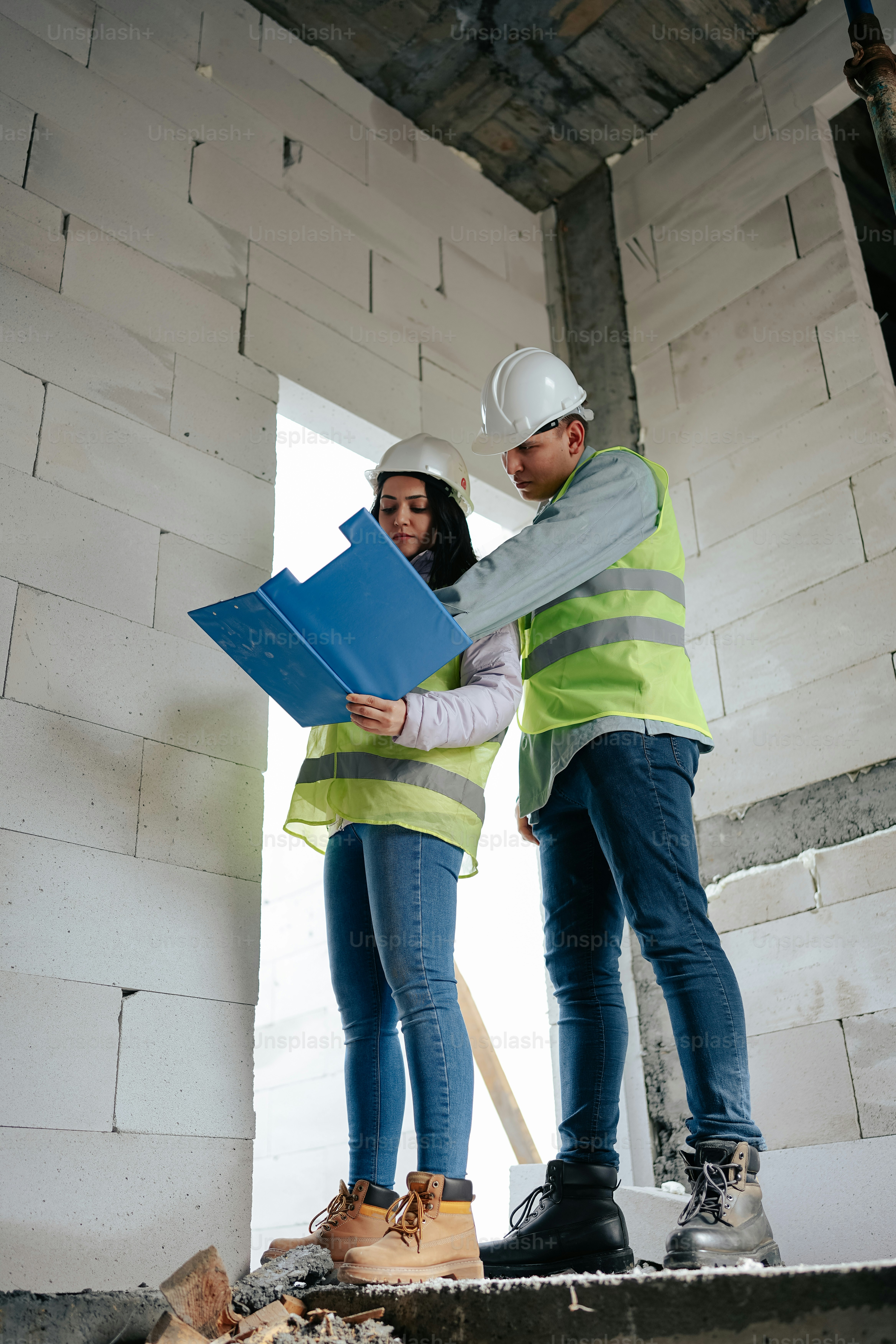 Ein Mann und eine Frau stehen in einem im Bau befindlichen Raum