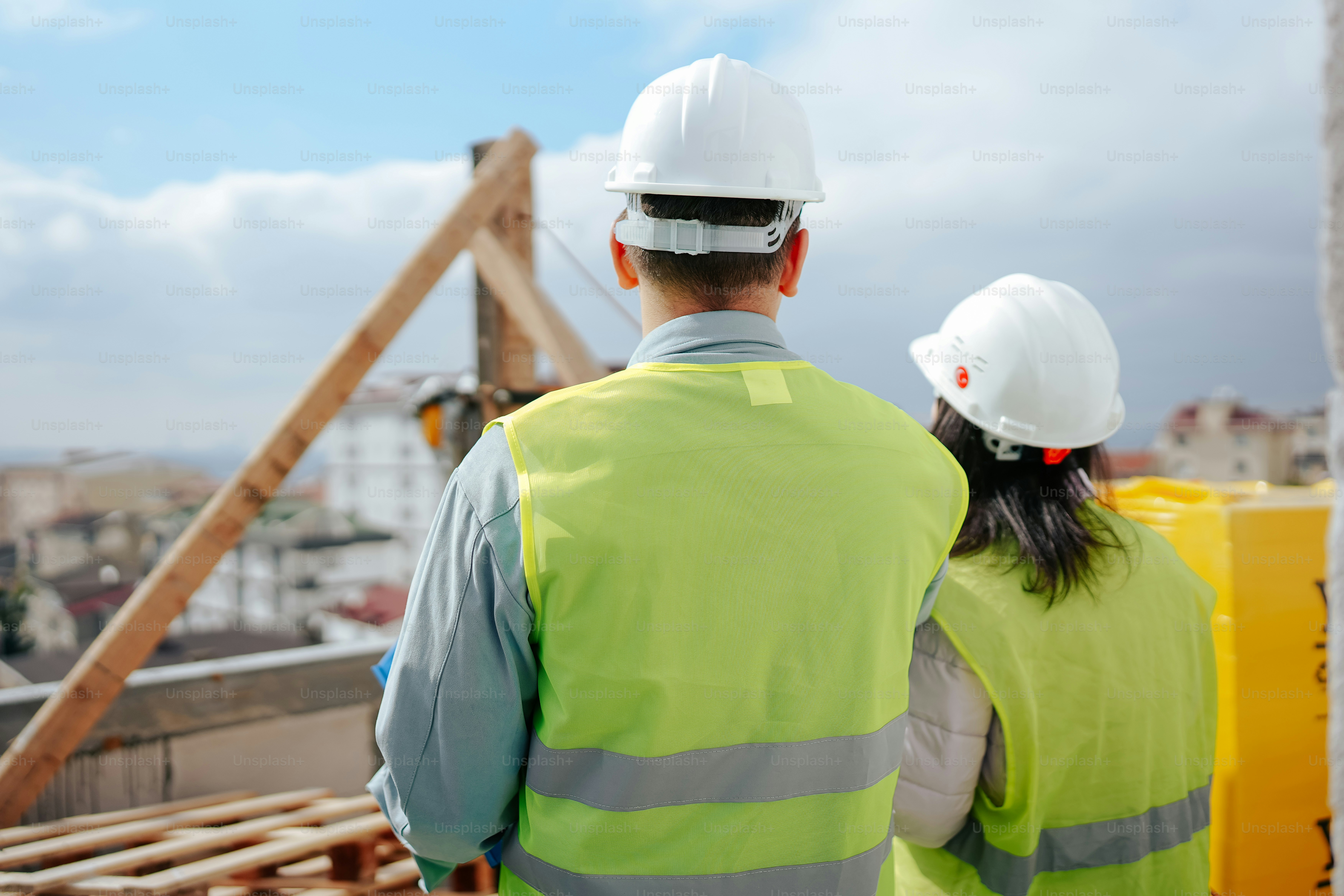 a man and a woman wearing safety vests and hard hats