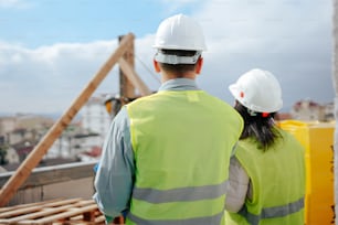 a man and a woman wearing safety vests and hard hats