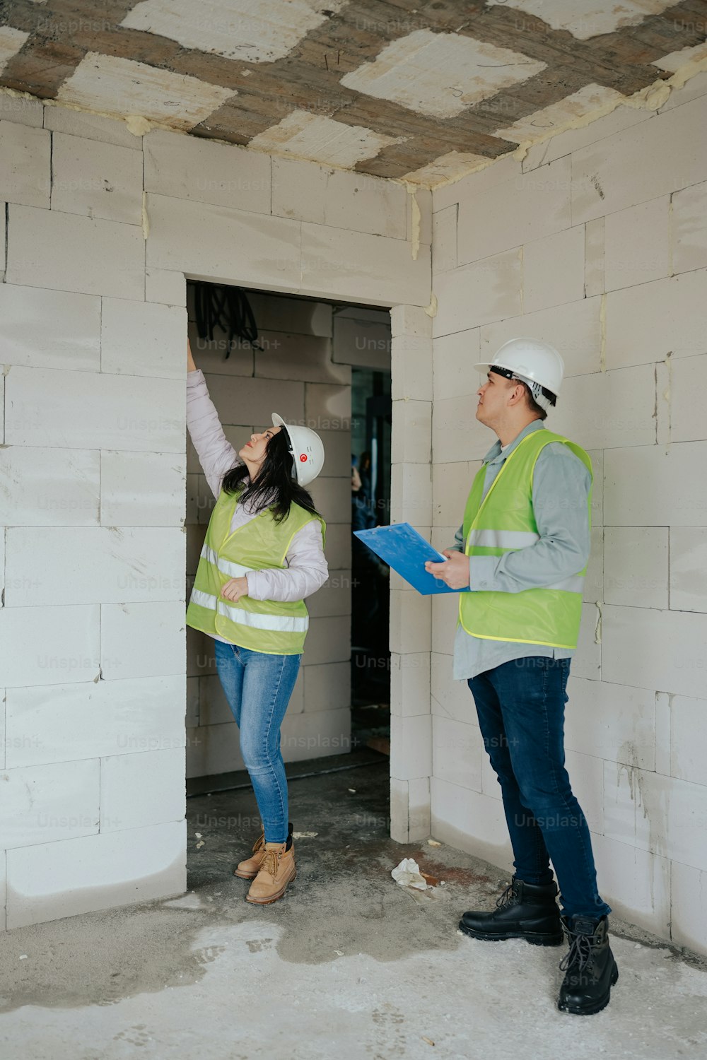 Un homme et une femme debout dans une pièce en construction