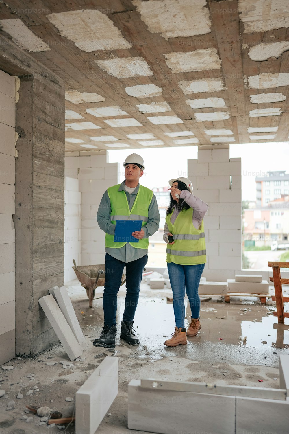 건설 중인 건물에 서 있는 남자와 여자
