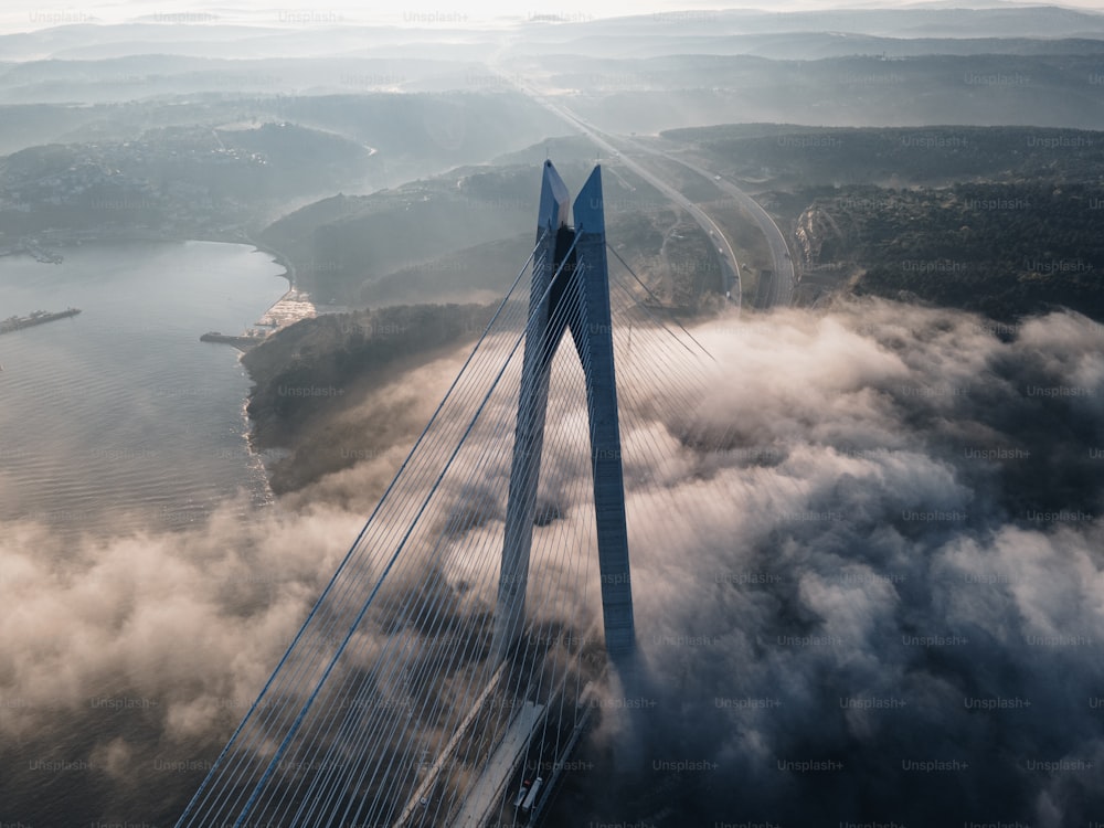 an aerial view of a bridge surrounded by clouds
