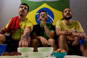three men sitting on a table with bowls of food