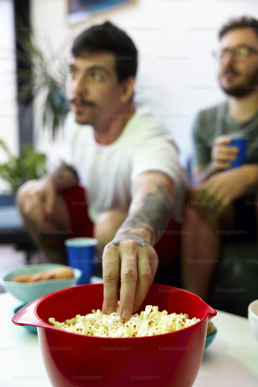 a man reaching for a bowl of popcorn