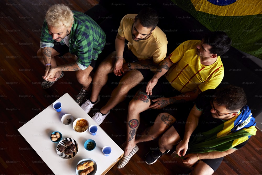 un groupe d’hommes assis autour d’une table avec des beignets dessus