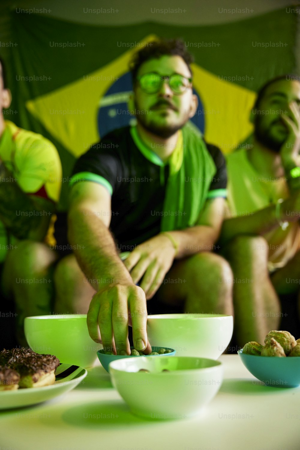 um grupo de homens sentados ao redor de uma mesa comendo comida
