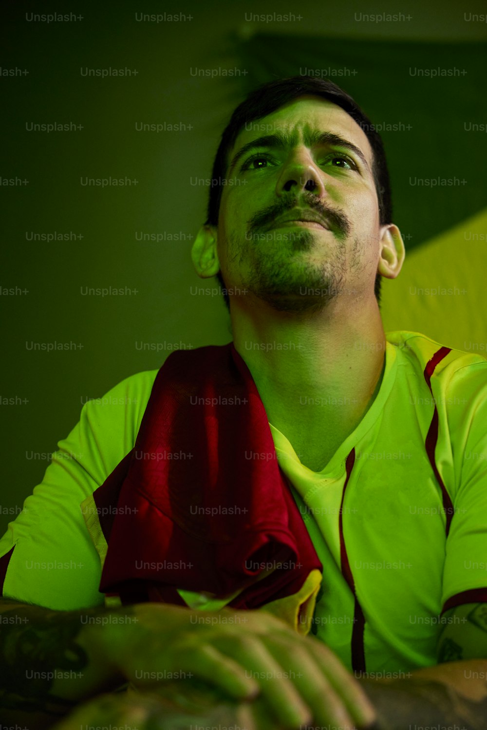 a man with a green shirt and a red scarf
