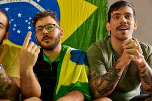 three men sitting next to each other in front of a flag