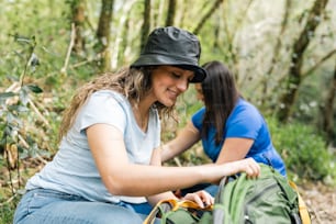 a couple of women sitting next to each other in the woods