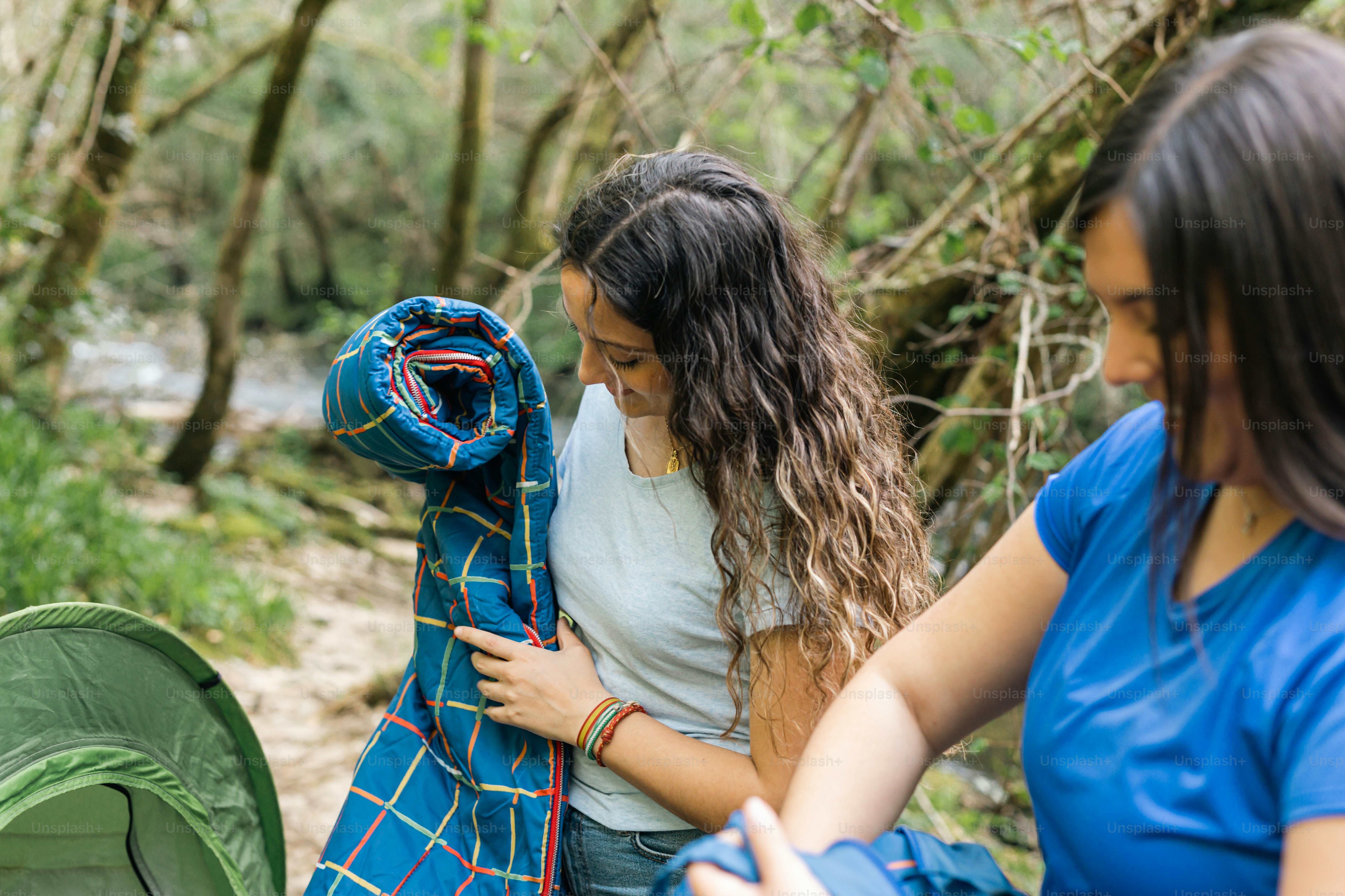 a couple of women standing next to a green tent