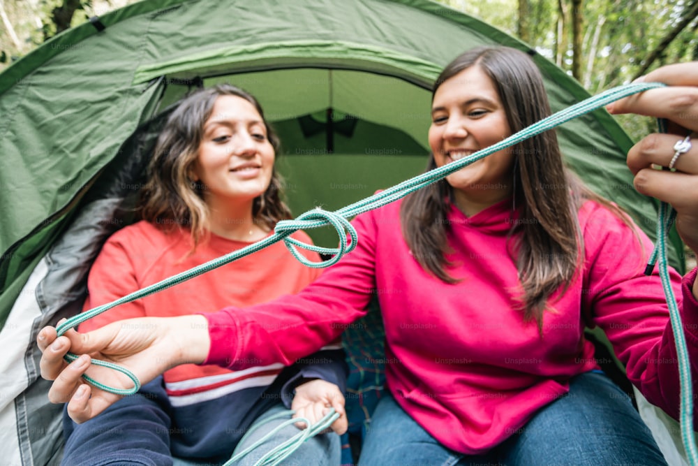 a couple of women sitting inside of a tent