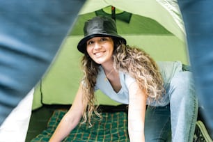 Una donna con un cappello è seduta in una tenda
