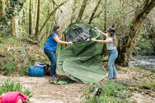 a couple of women standing next to a tent