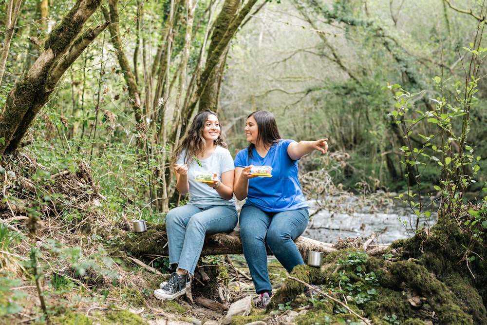 Zwei Frauen sitzen auf einer Bank im Wald