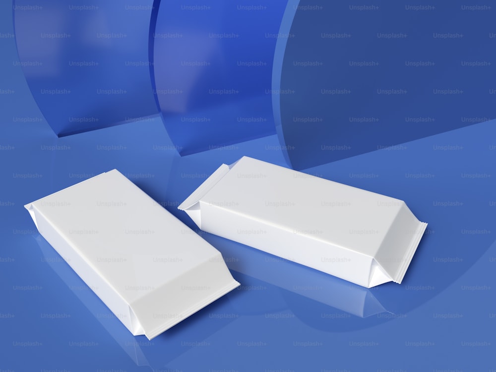 un paio di scatole bianche sedute sopra una superficie blu