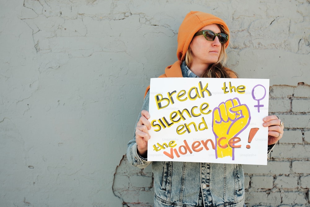 a woman holding a sign that says break the science and we are violence