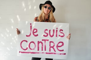Una mujer sosteniendo un cartel que dice je suis contre