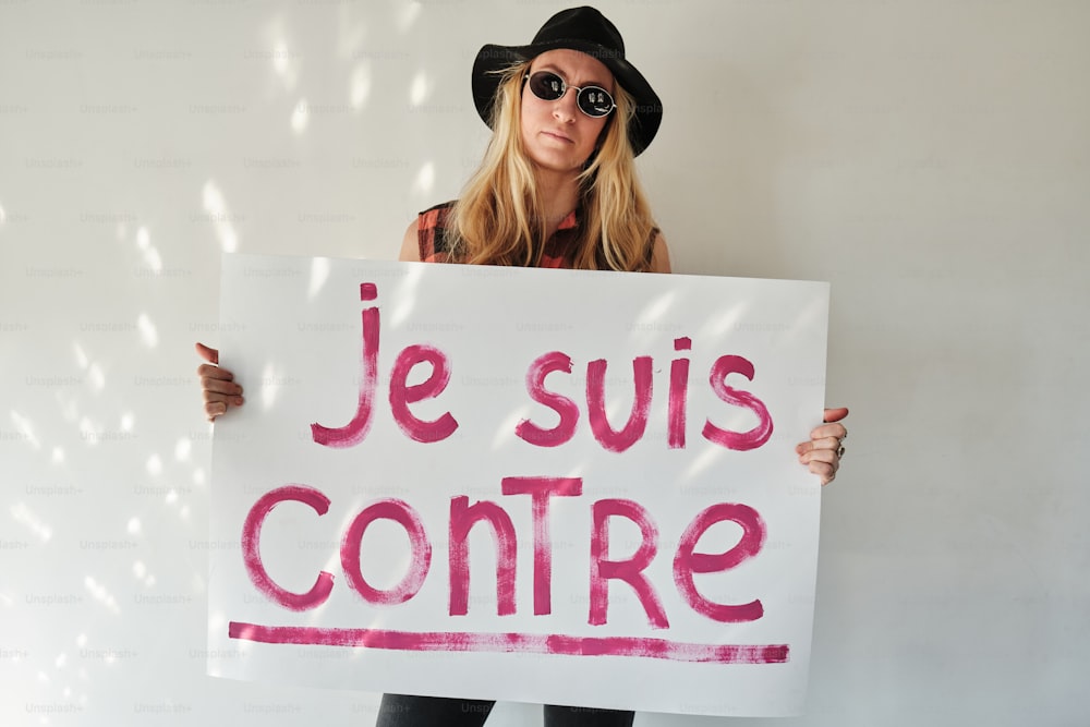 a woman holding a sign that says je suis contre