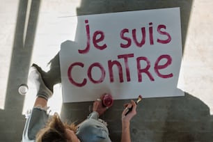 Eine Person, die ein Schild mit der Aufschrift "Je suis contre" hält