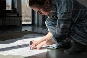 a woman is writing on a piece of paper