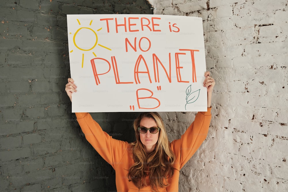 Una mujer sosteniendo un cartel que dice que no hay planeta B