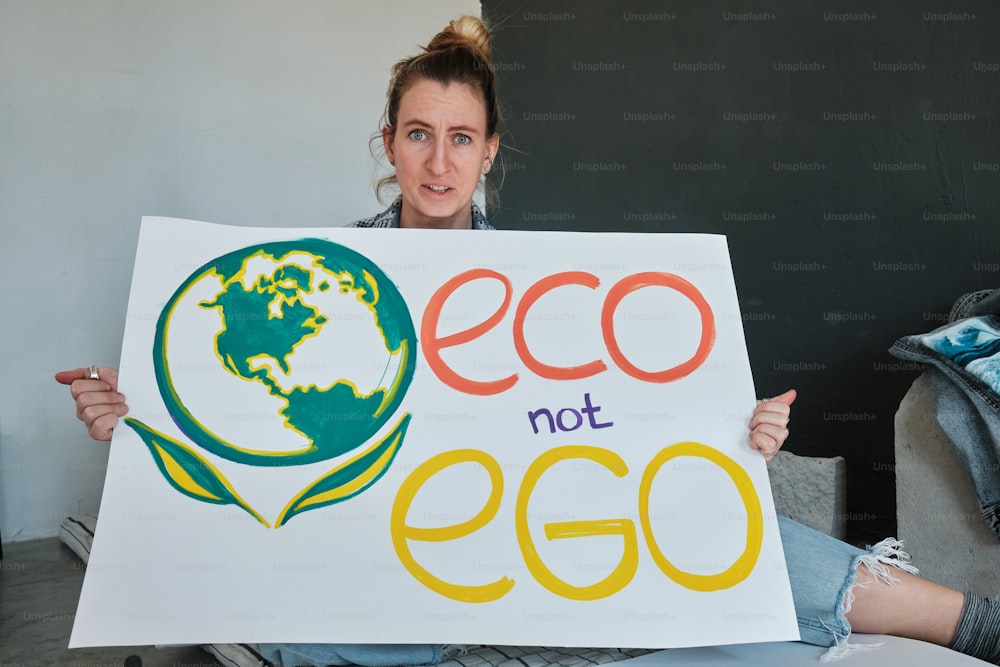 a woman holding a sign that says eco not egg