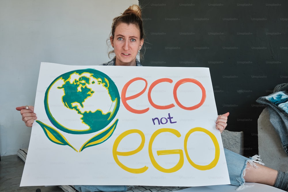 Eine Frau, die ein Schild mit der Aufschrift Eco not Egg hält