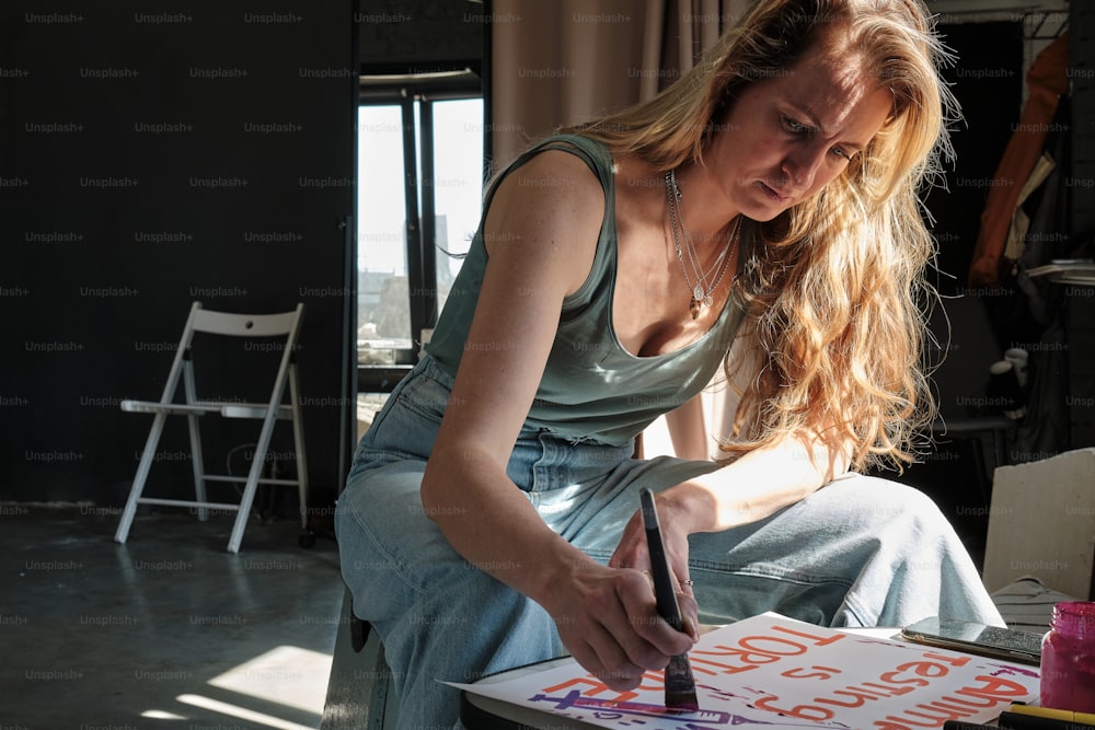 a woman sitting on a chair writing on a piece of paper