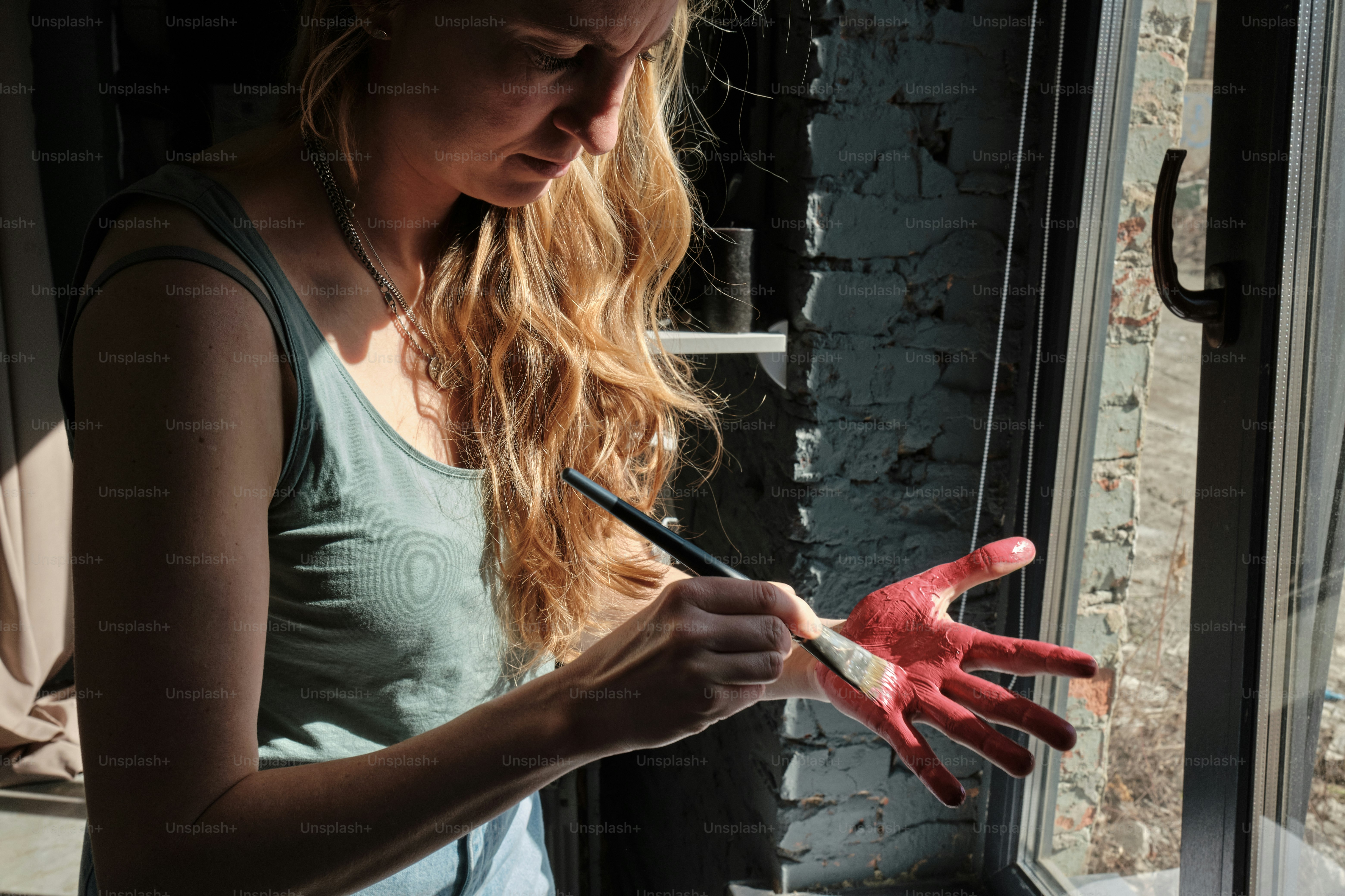 a woman holding a paintbrush and a pair of red gloves