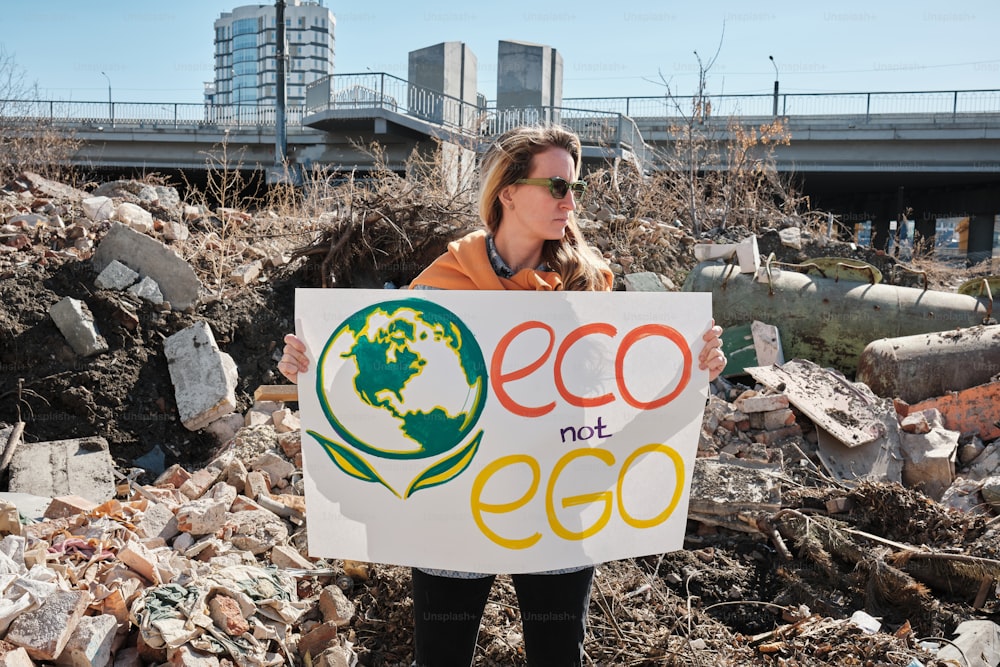 Eine Frau, die ein Schild mit der Aufschrift Eco not Eco hält