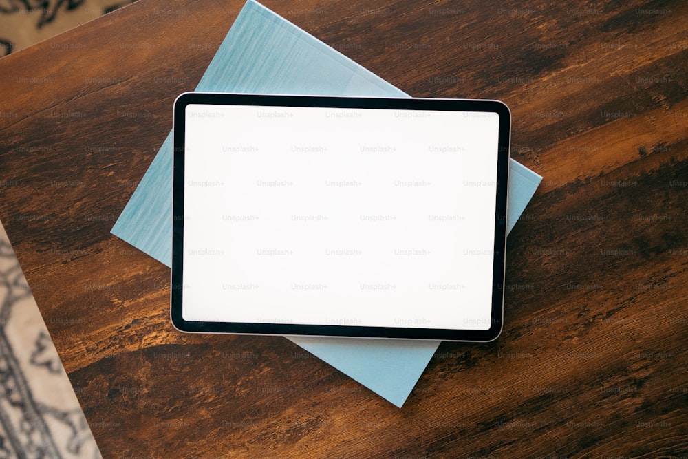 a tablet computer sitting on top of a wooden table