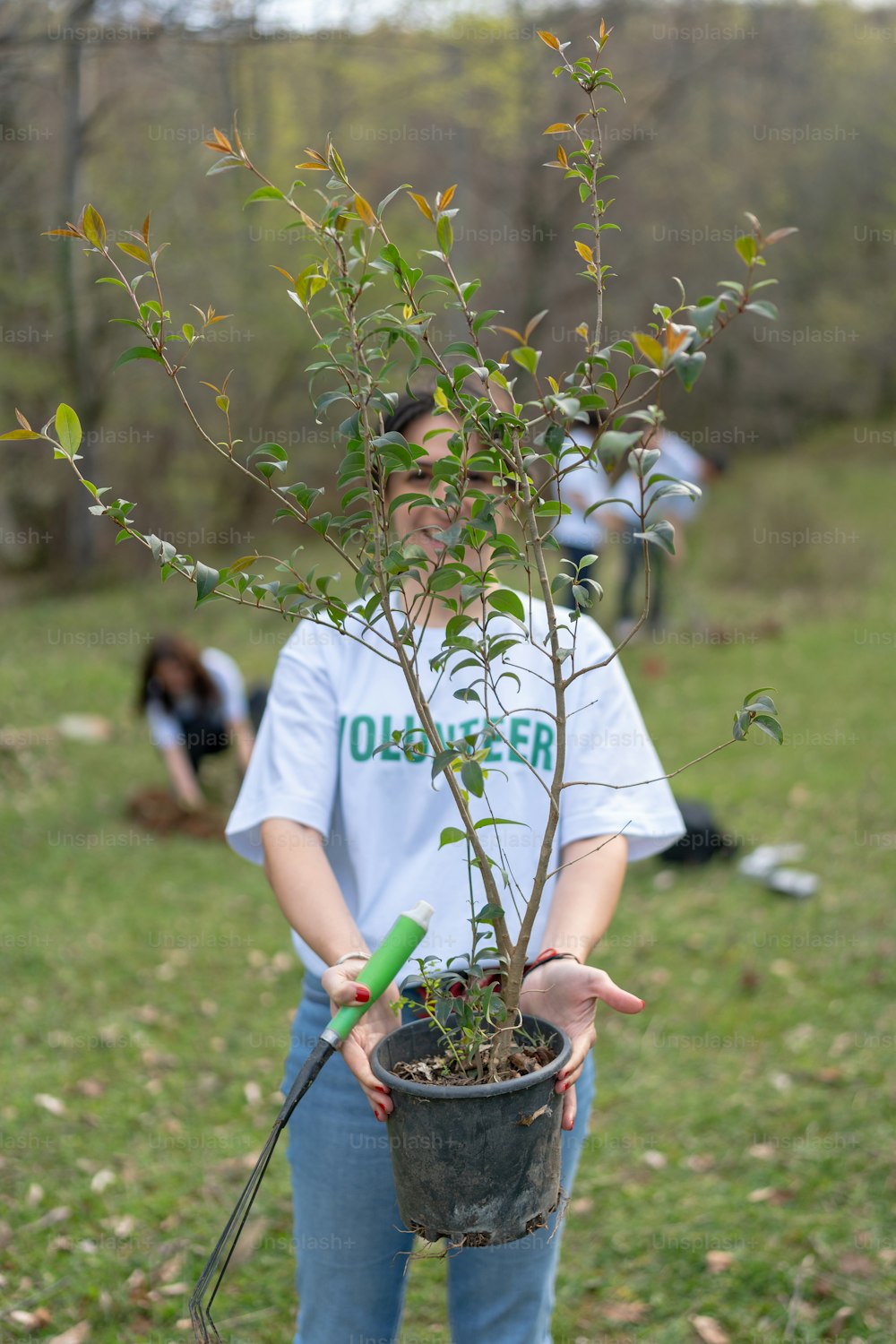 a woman holding a potted plant in her hands