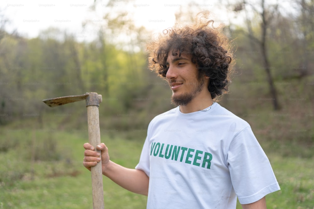 a man holding a wooden stick in a field