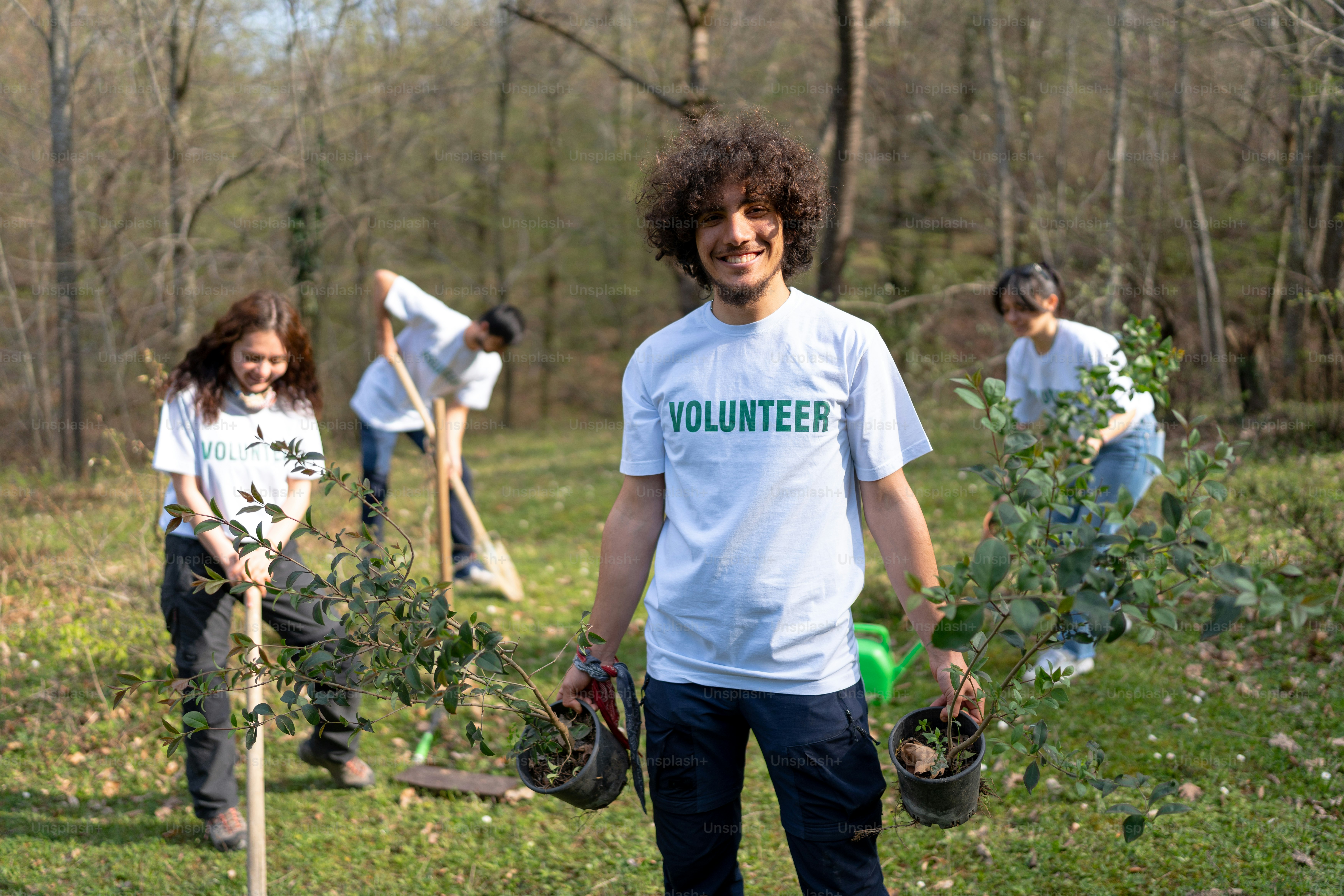 a group of young people holding shovels and trees