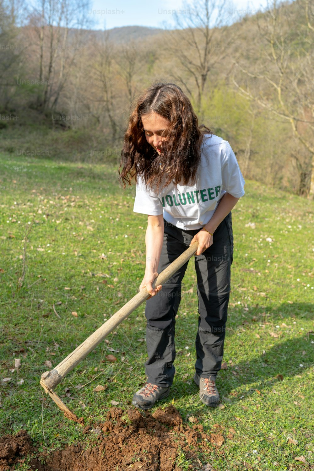 a woman digging a hole in the grass