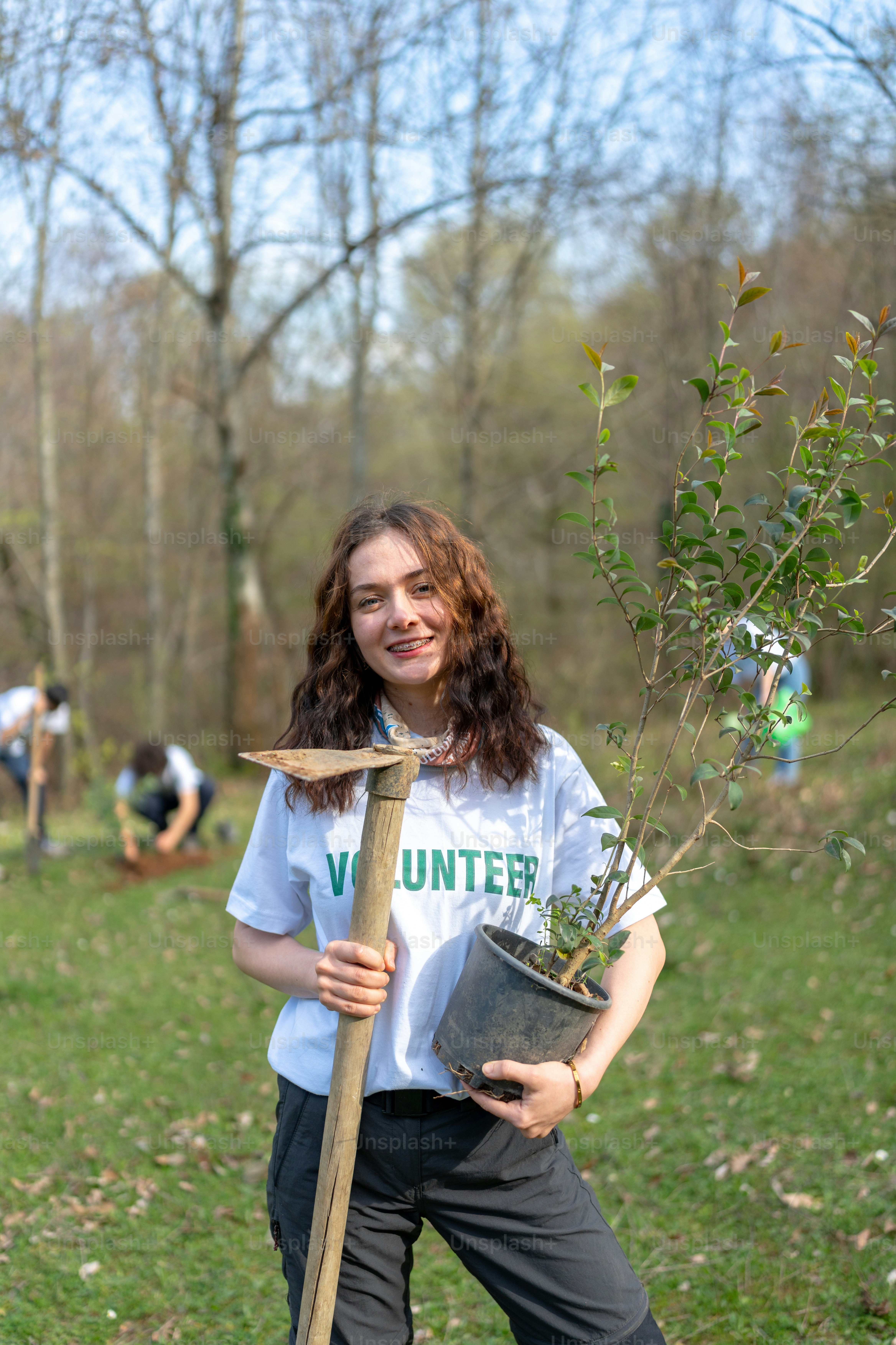 Une femme tenant un arbre dans un parc