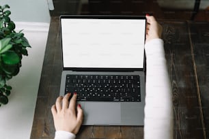 a woman using a laptop computer on a wooden table