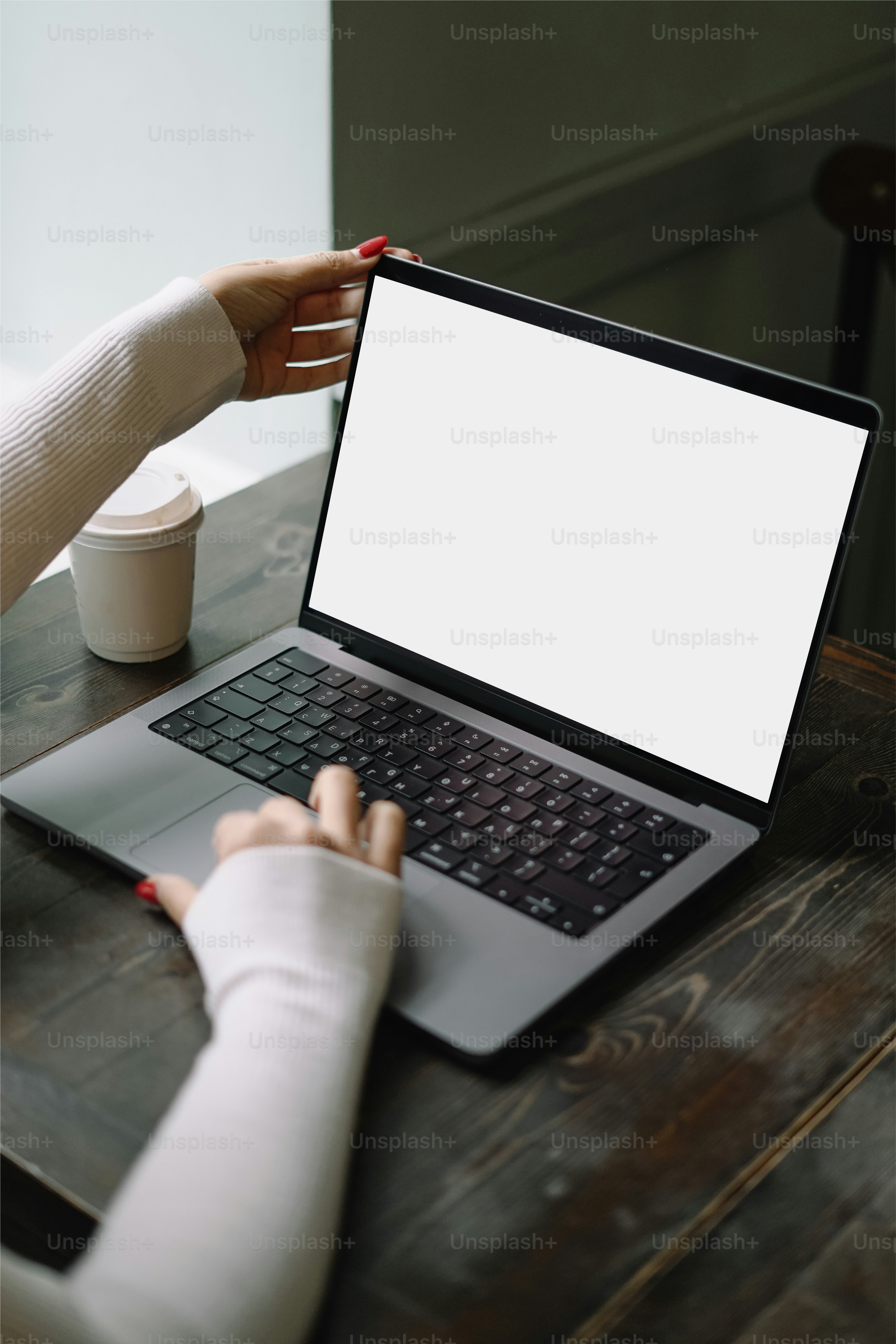 a woman sitting at a table using a laptop computer
