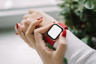 a woman with red nails holding a cell phone