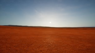 the sun is setting over a barren plain