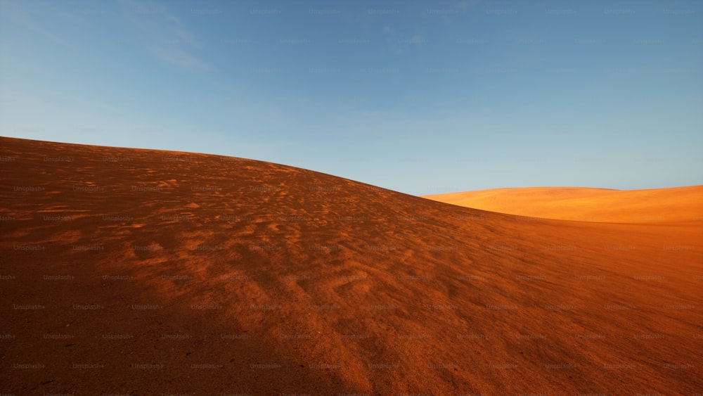 Una colina de arena con un cielo azul en el fondo