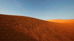 a sandy hill with a blue sky in the background