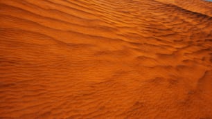 Eine orangefarbene Wüste mit blauem Himmel im Hintergrund