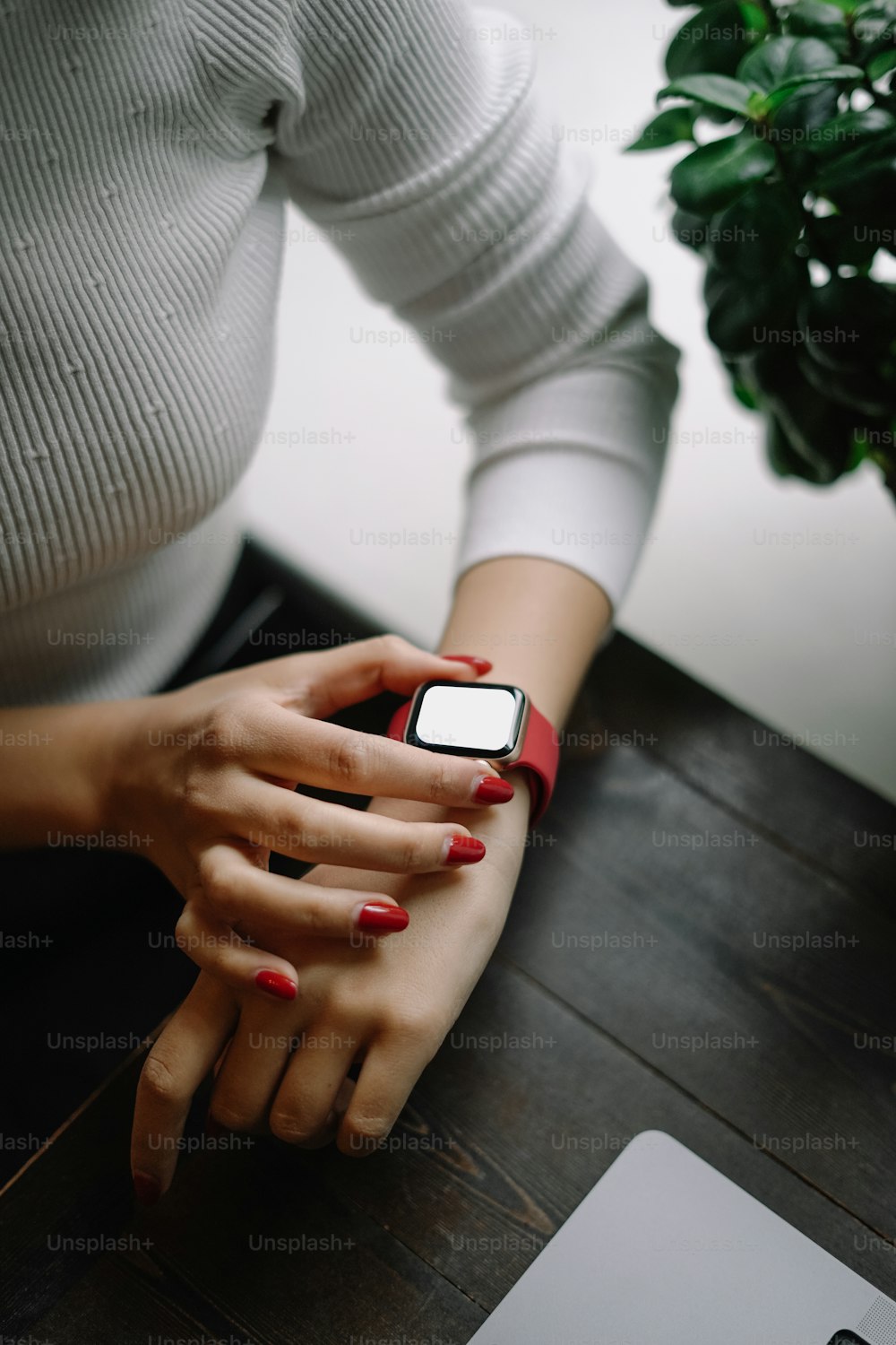 Une femme assise à une table avec un téléphone portable à la main