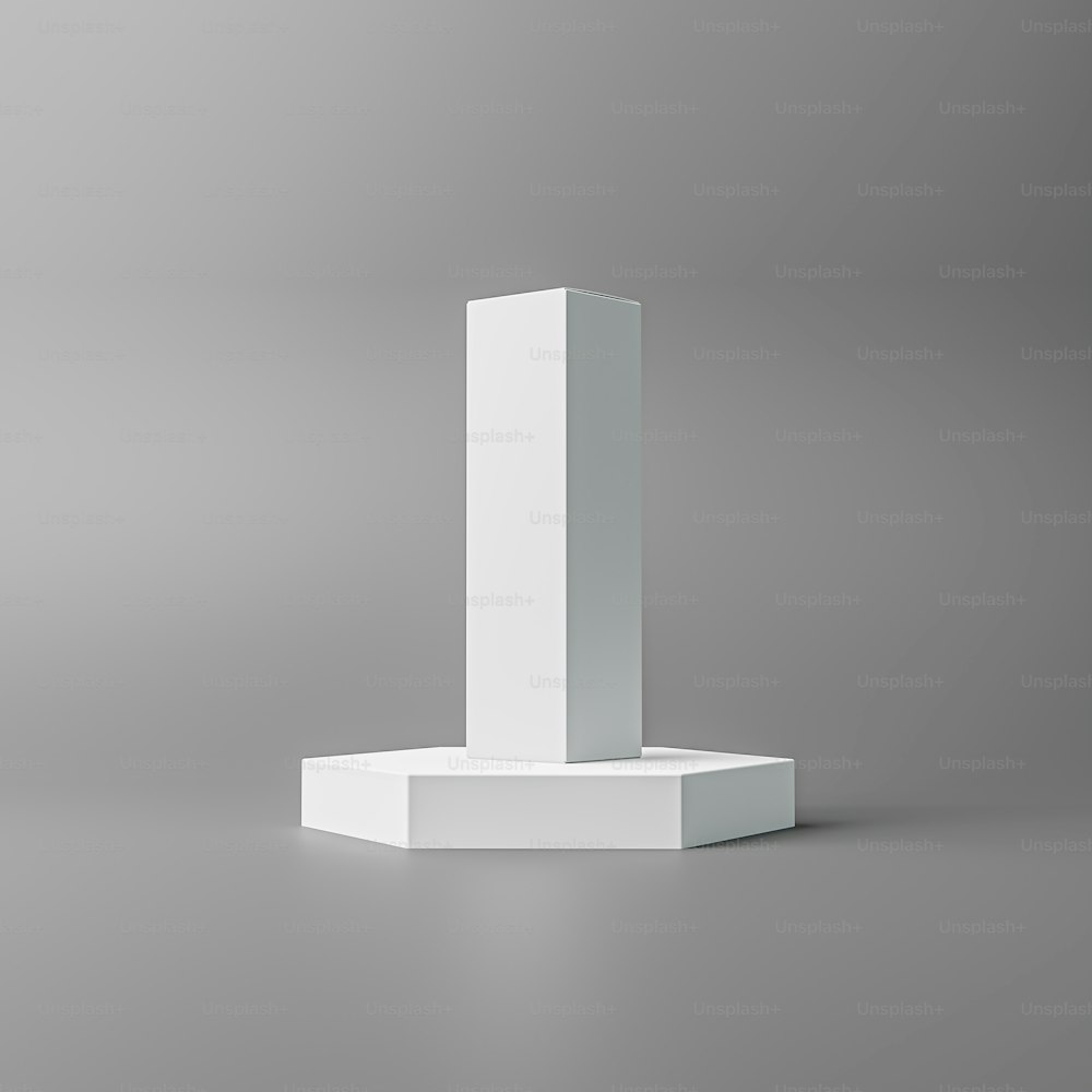 um pedestal branco fica em uma superfície cinza