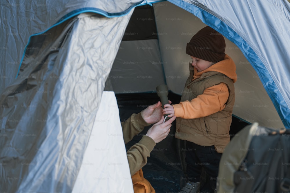 a person in a tent putting something in a person's hand