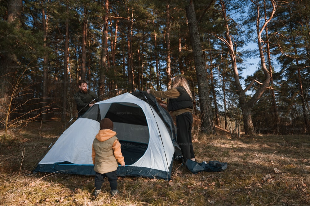 Un hombre y un niño montando una tienda de campaña en el bosque