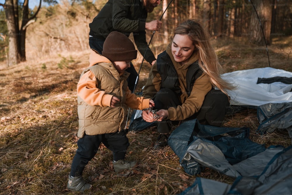 a woman and a child are camping in the woods